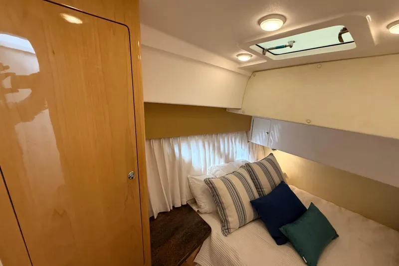 Slide: The Image of Cozy cabin interior of 2016 Intrepid 430 Sport Yacht with pillows and wood paneling. - 12