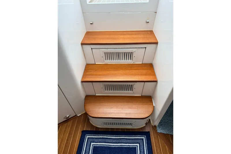 Slide: The Image of Wooden steps inside a 2016 Intrepid 430 Sport Yacht, featuring vented panels. - 13