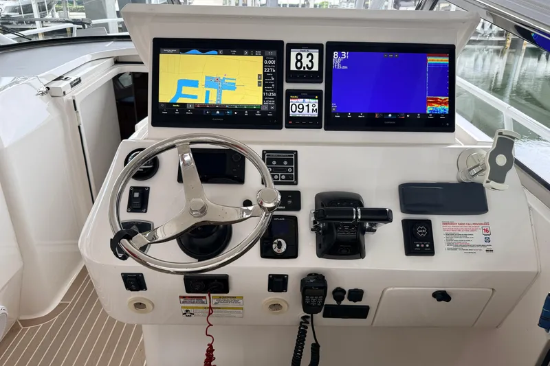 Slide: The Image of Control panel of a 2016 Intrepid 430 Sport Yacht with navigation screens and steering wheel. - 14