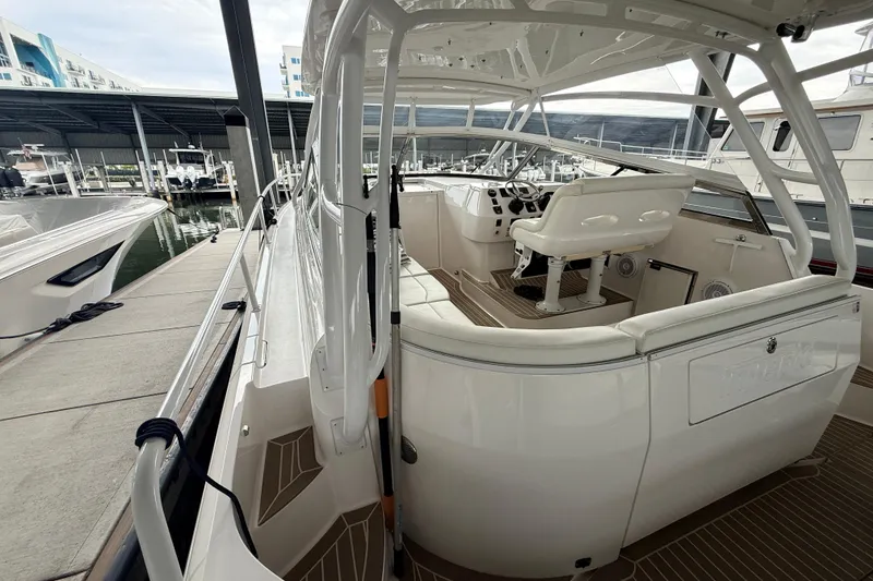 Slide: The Image of 2016 Intrepid 430 Sport Yacht docked, showcasing sleek design and spacious cockpit area. - 22