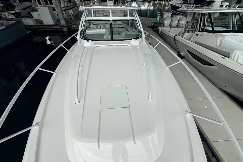 Slide: The Image of 2016 Intrepid 430 Sport Yacht docked, showcasing sleek white deck design. - 25