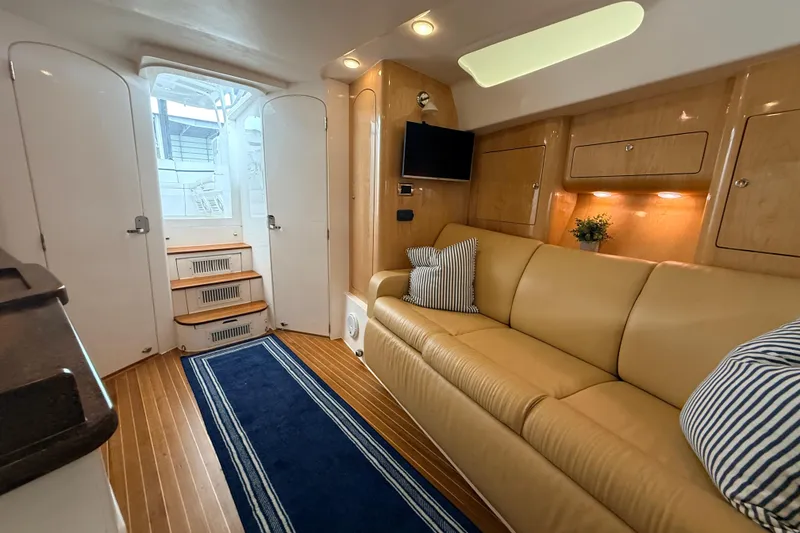 Slide: The Image of Interior of 2016 Intrepid 430 Sport Yacht with beige sofa and striped cushions. - 7