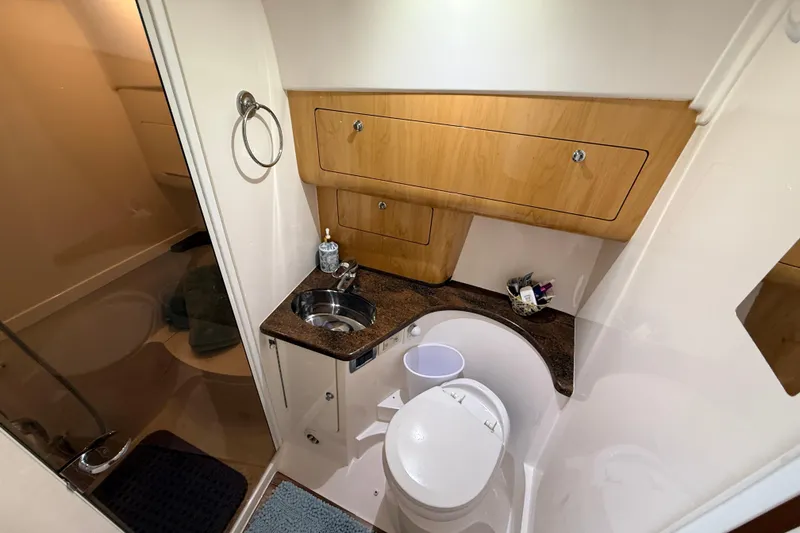 Slide: The Image of Bathroom interior of 2016 Intrepid 430 Sport Yacht with sink, toilet, and wooden cabinetry. - 9