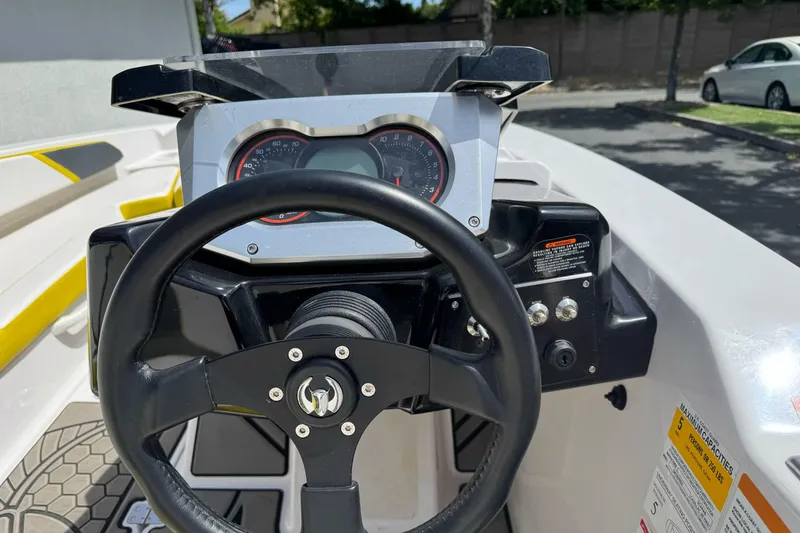 Slide: The Image of Steering wheel and dashboard of a 2017 Scarab 165 G boat, featuring speedometer and controls. - 10