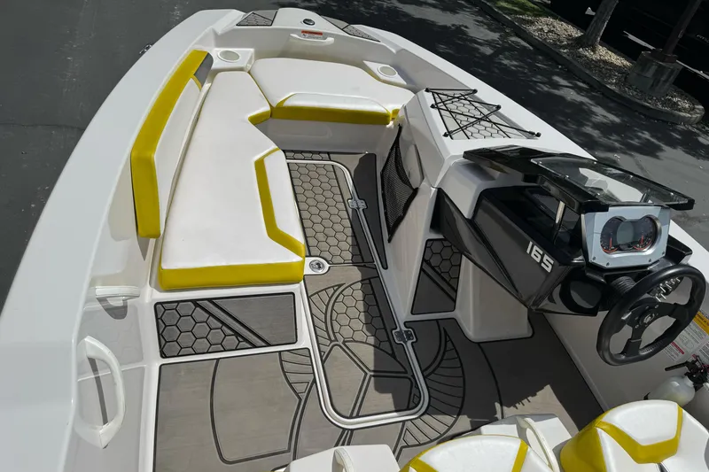 Slide: The Image of Interior of 2017 Scarab 165 G boat with yellow and white seating, modern dashboard. - 13