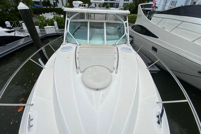 Slide: The Image of 2014 Wellcraft 340 Coastal boat docked, featuring sleek white design and spacious deck. - 11