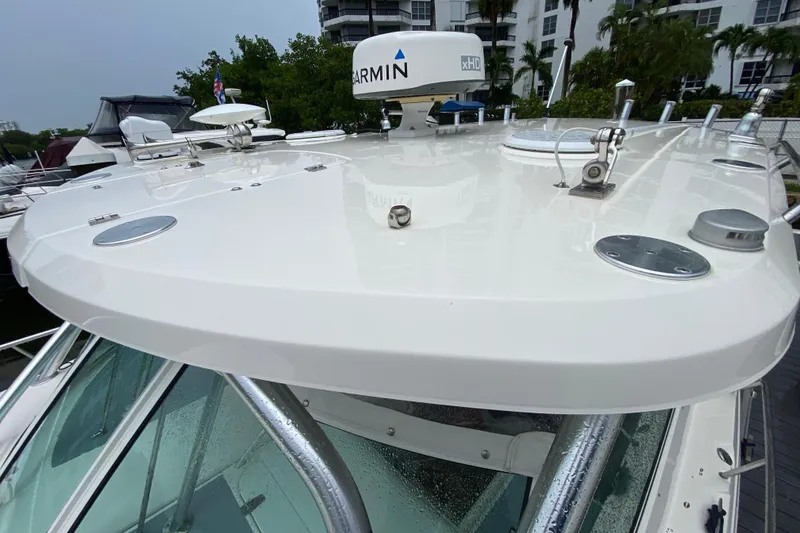 Slide: The Image of 2014 Wellcraft 340 Coastal boat with Garmin radar, docked near lush greenery. - 15