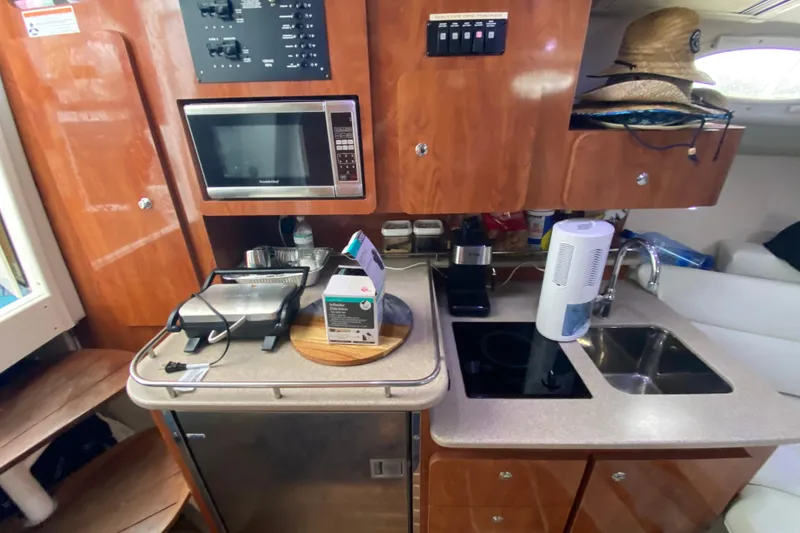 Slide: The Image of 2014 Wellcraft 340 Coastal boat kitchen with microwave, sink, and appliances. - 19