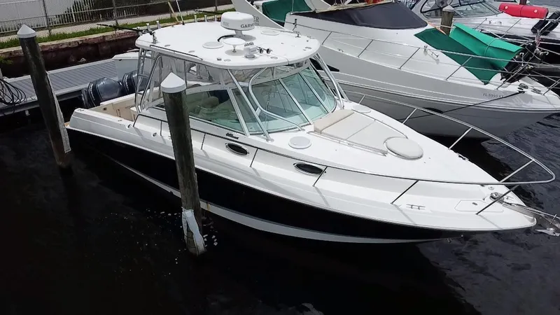 Slide: The Image of 2014 Wellcraft 340 Coastal boat docked at marina, featuring sleek design and spacious deck. - 2