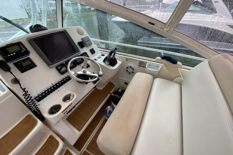 Slide: The Image of 2014 Wellcraft 340 Coastal boat cockpit with steering wheel and navigation equipment. - 25