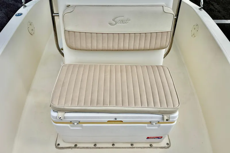 Slide: The Image of Scout 172 Sportfish 2001 boat seat with beige cushioned upholstery and integrated cooler. - 11