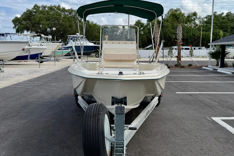 Slide: The Image of 2001 Scout 172 Sportfish boat on trailer with canopy in parking lot. - 2