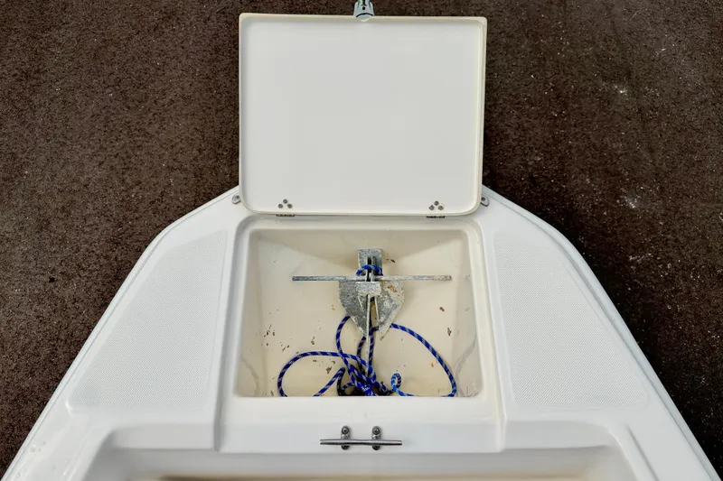 Slide: The Image of Open anchor compartment on 2001 Scout 172 Sportfish boat with blue rope. - 25