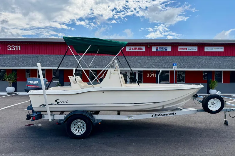 Slide: The Image of 2001 Scout 172 Sportfish boat on trailer, parked outside a marine dealership. - 4
