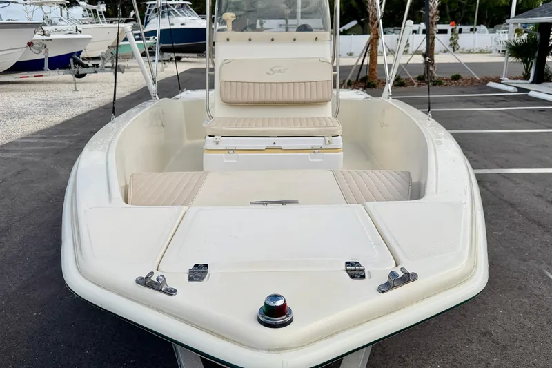 Slide: The Image of 2001 Scout 172 Sportfish boat with beige seating, parked in a marina. - 8