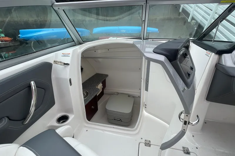 Slide: The Image of 2014 Chaparral 224 Sunesta boat interior with compact cabin and seating area. - 18
