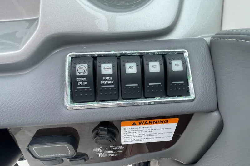 Slide: The Image of Control panel of a 2014 Chaparral 224 Sunesta boat with switches and warning label. - 27