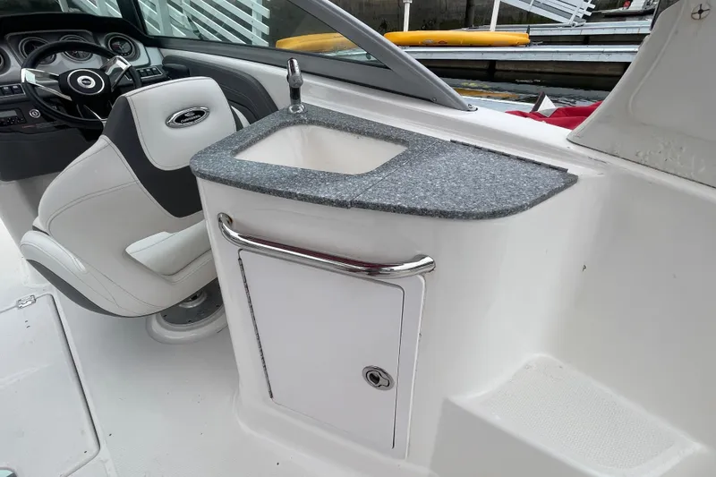 Slide: The Image of 2014 Chaparral 224 Sunesta boat interior with steering wheel and sink area. - 28