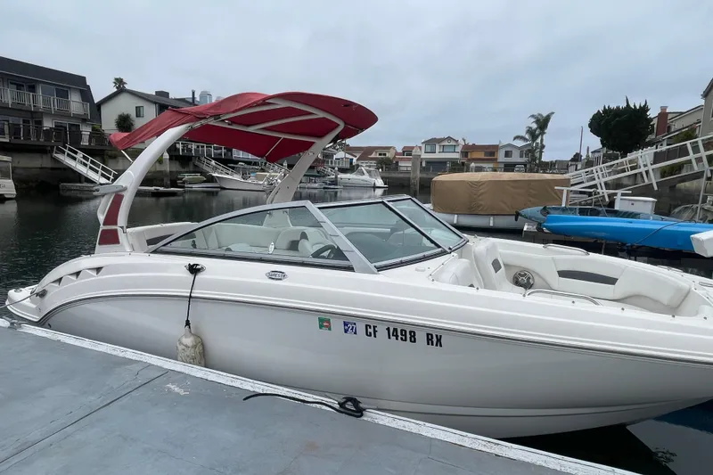 Slide: The Image of 2014 Chaparral 224 Sunesta boat docked in a marina with red canopy. - 3