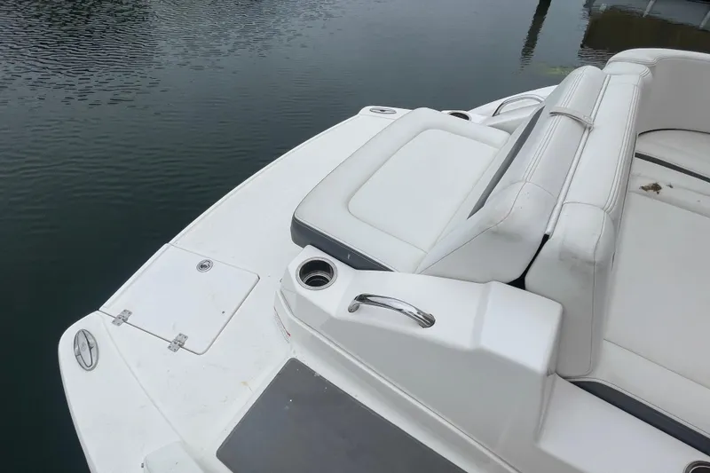 Slide: The Image of 2014 Chaparral 224 Sunesta boat with white seating and cup holder on calm water. - 34