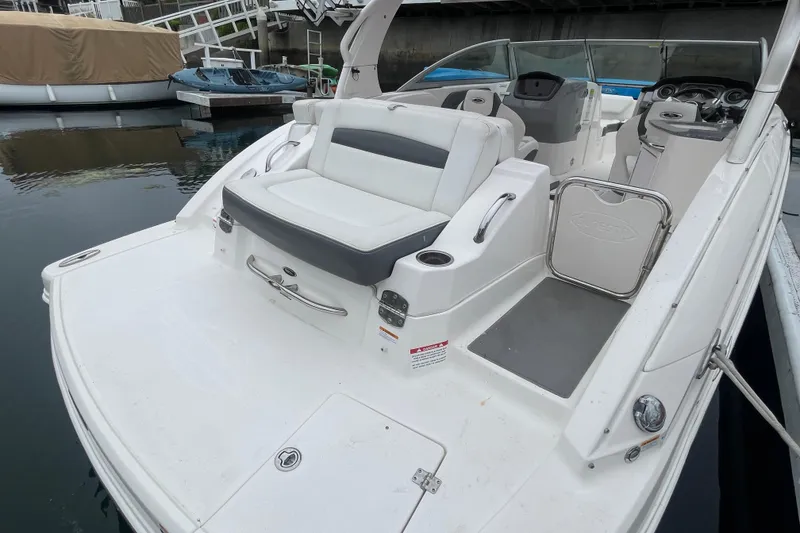 Slide: The Image of 2014 Chaparral 224 Sunesta boat with spacious seating and sleek design at a dock. - 35