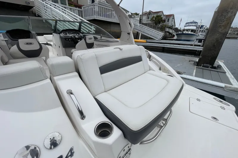 Slide: The Image of 2014 Chaparral 224 Sunesta boat interior with white seating at a dock. - 37