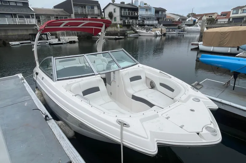 Slide: The Image of 2014 Chaparral 224 Sunesta boat docked in a serene marina setting. - 4