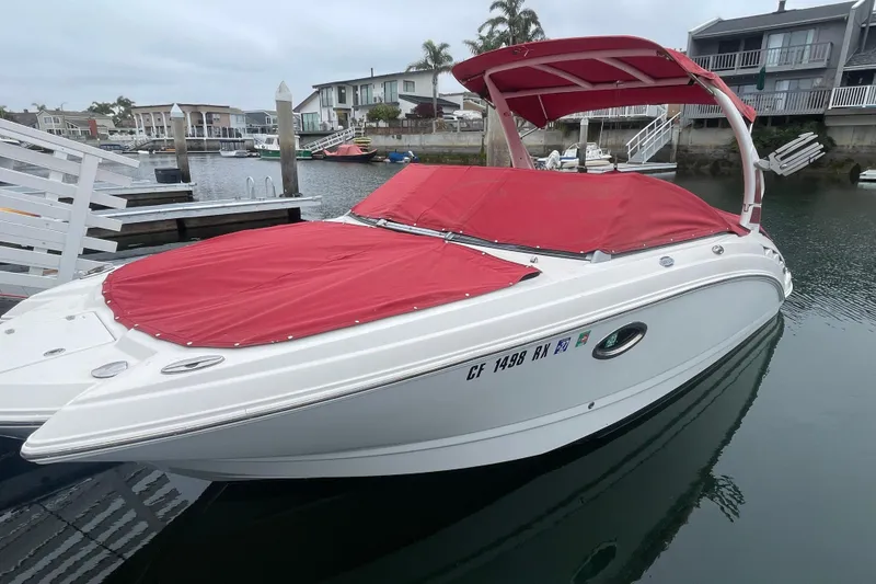 Slide: The Image of 2014 Chaparral 224 Sunesta boat with red covers docked in a marina. - 44
