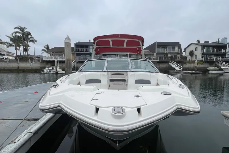 Slide: The Image of 2014 Chaparral 224 Sunesta boat docked in a marina with waterfront homes. - 6