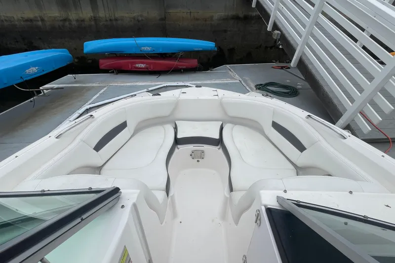 Slide: The Image of 2014 Chaparral 224 Sunesta boat interior with white seating at dock. - 8