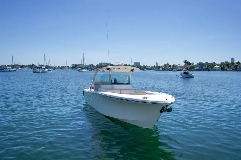 Slide: The Image of 2014 Pursuit ST 310 Sport boat on calm water, clear sky, distant shoreline. - 4