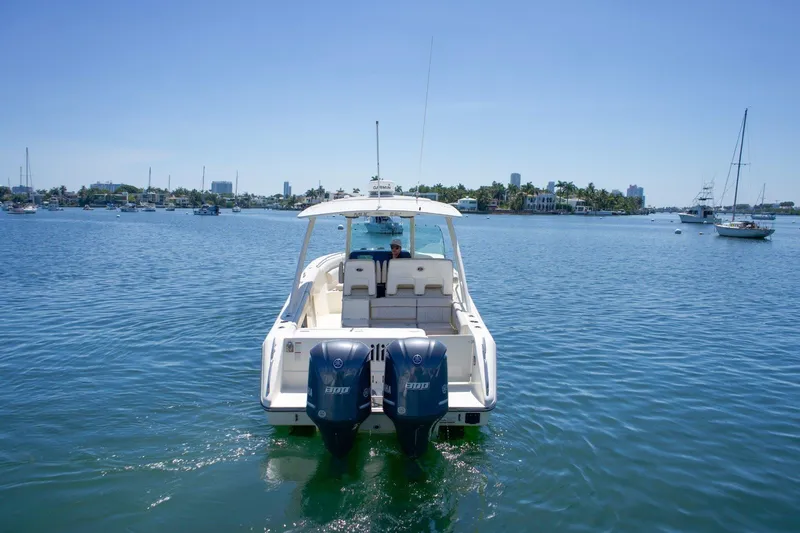 Slide: The Image of 2014 Pursuit ST 310 Sport boat cruising on a sunny day in a scenic harbor. - 5