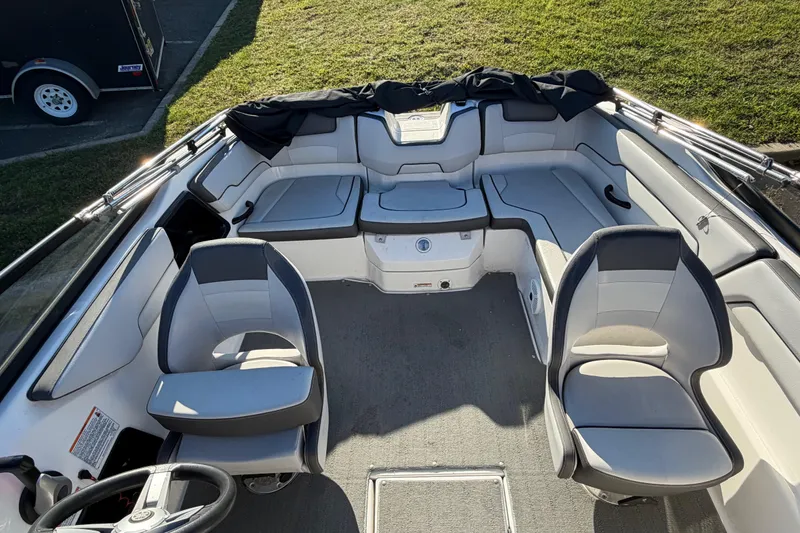 Slide: The Image of 2019 Yamaha Boats SX190 interior with seating and steering wheel, parked on grass. - 8