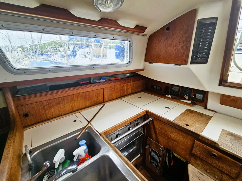 Slide: The Image of Interior of a 1985 Sabre 34 yacht with kitchen and wood paneling. - 12