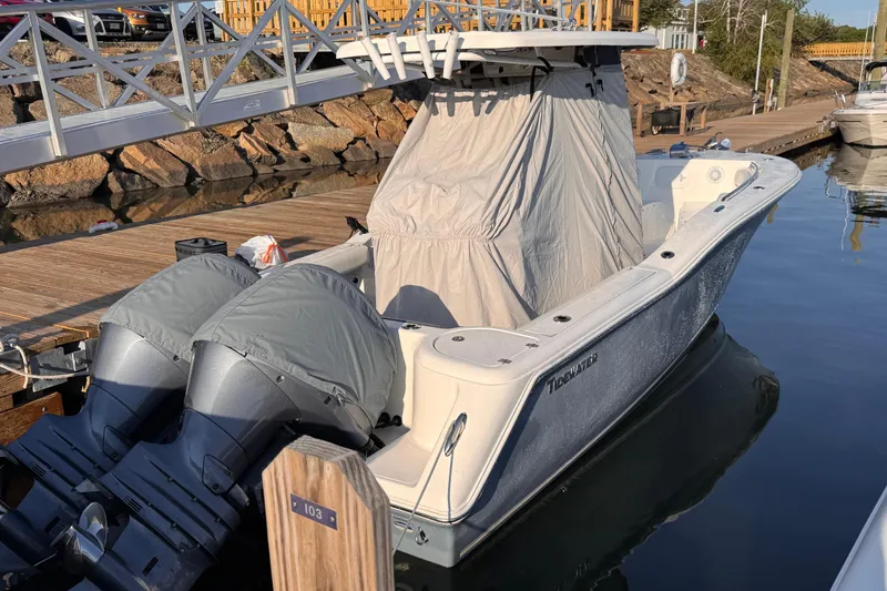 The Image of 2015 Tidewater 252 CC Adventure boat docked with covered engines and console. - 0