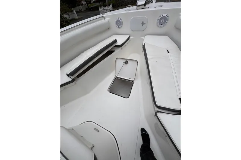 Slide: The Image of 2015 Tidewater 252 CC Adventure boat interior with white seating and storage compartments. - 17