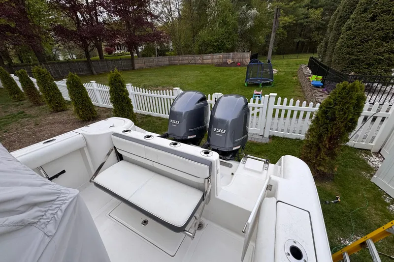 Slide: The Image of 2015 Tidewater 252 CC Adventure boat with dual 150 horsepower engines in a backyard setting. - 25
