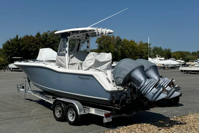 Slide: The Image of 2015 Tidewater 252 CC Adventure boat on trailer, parked outdoors under clear sky. - 5