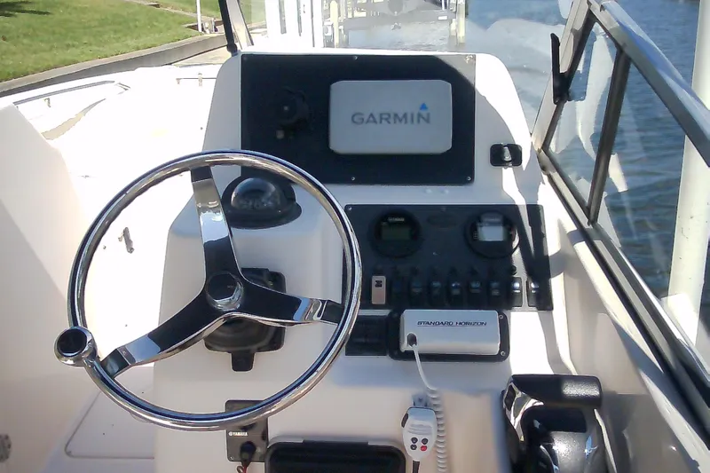 Slide: The Image of 2005 Grady-White Tournament 225 boat dashboard with Garmin navigation system and steering wheel. - 19