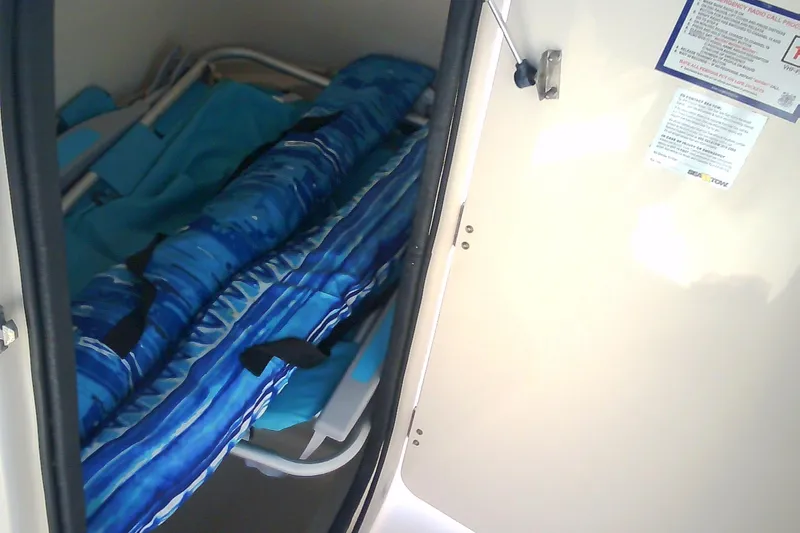 Slide: The Image of Storage compartment in a 2005 Grady-White Tournament 225 boat with blue gear inside. - 25