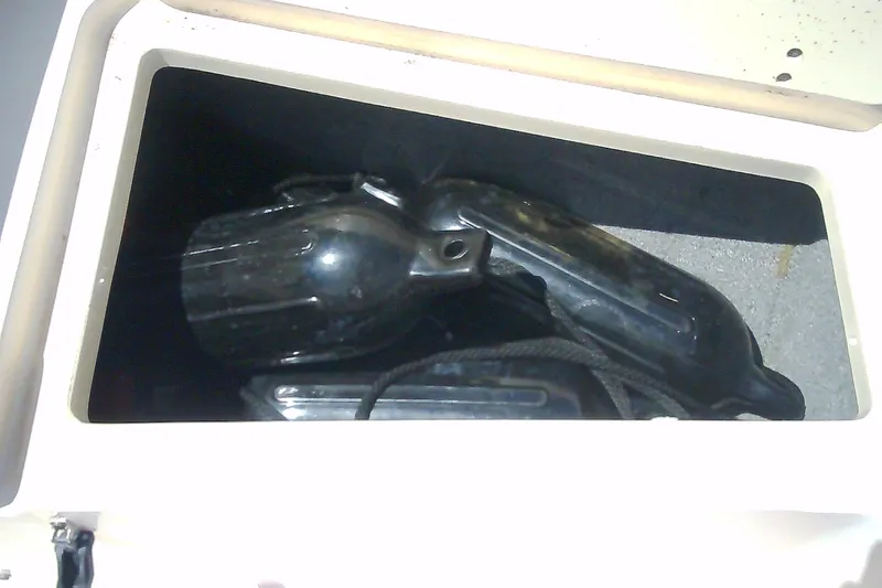 Slide: The Image of Storage compartment on a 2005 Grady-White Tournament 225 boat with black equipment inside. - 27