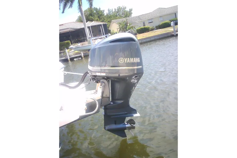 Slide: The Image of Yamaha outboard motor on 2005 Grady-White Tournament 225 boat, docked by waterfront homes. - 34