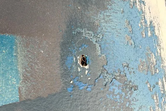 Slide: The Image of Damaged hull of 2005 Grady-White Tournament 225 with peeling blue paint. - 36