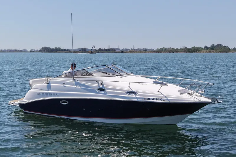 The Image of 2006 Regal Commodore 2665 boat cruising on a calm lake under a clear sky. - 0
