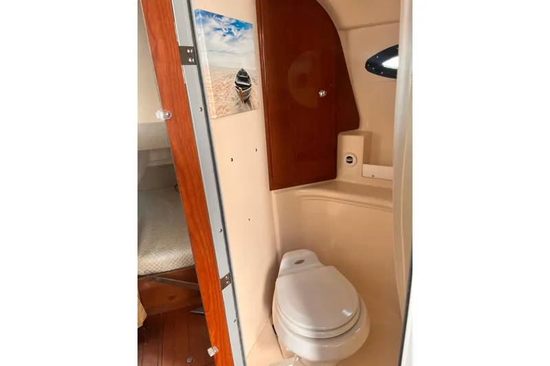 Slide: The Image of Compact bathroom in 2006 Regal Commodore 2665 boat with wooden accents and artwork. - 10