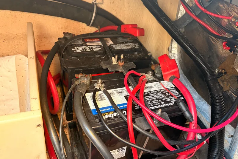 Slide: The Image of Battery compartment of a 2006 Regal Commodore 2665 with connected cables. - 14