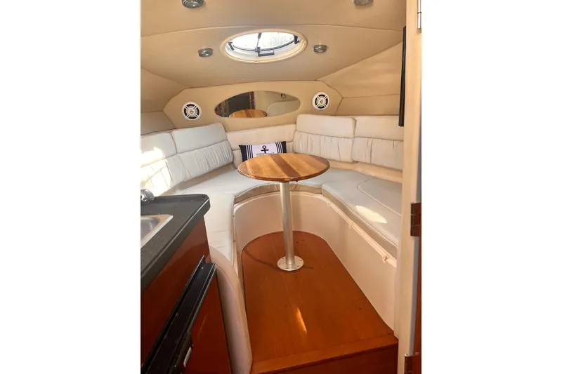 Slide: The Image of Interior of 2006 Regal Commodore 2665 boat with cozy seating and wooden table. - 7
