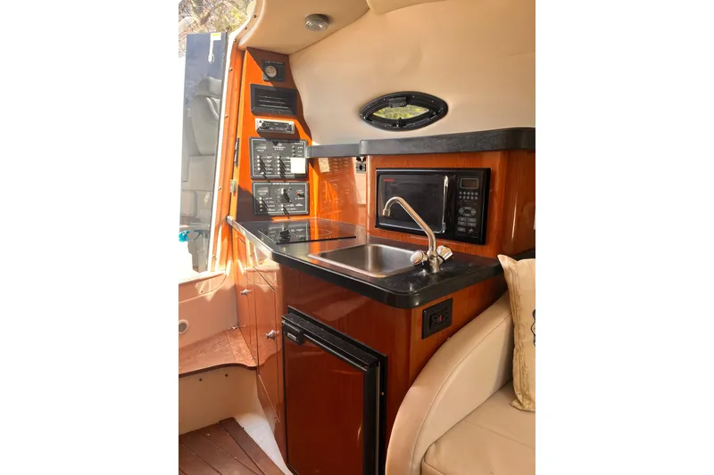 Slide: The Image of 2006 Regal Commodore 2665 boat interior with kitchenette, sink, and microwave. - 8
