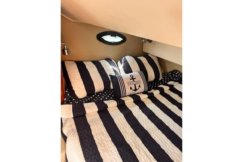 Slide: The Image of Cozy cabin bed in 2006 Regal Commodore 2665 with nautical-themed bedding. - 9