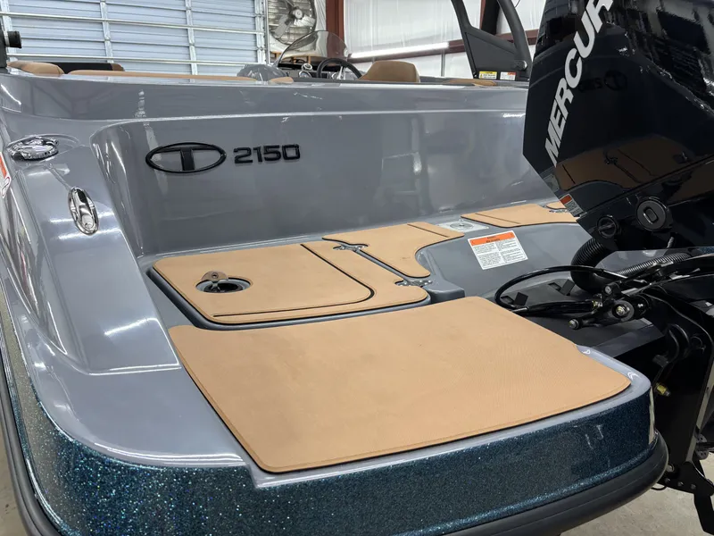 Slide: The Image of 2026 Tahoe Deck 2150 boat with Mercury engine in a garage. - 15